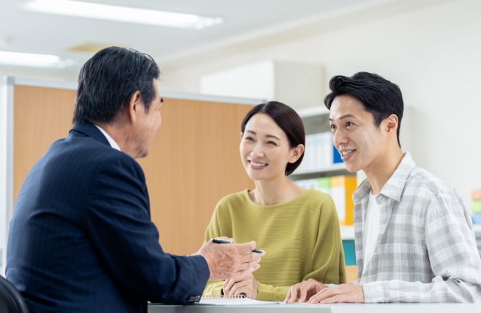 笑顔で相談を行う夫婦と担当者