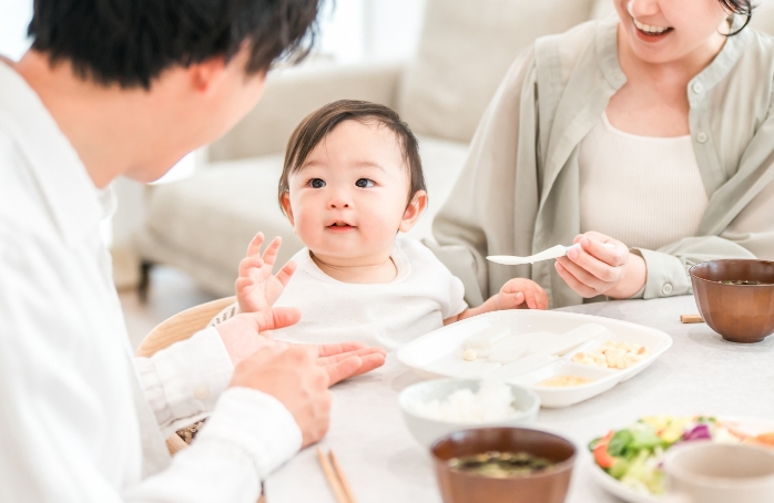 夫婦と食事をしている幼い子供